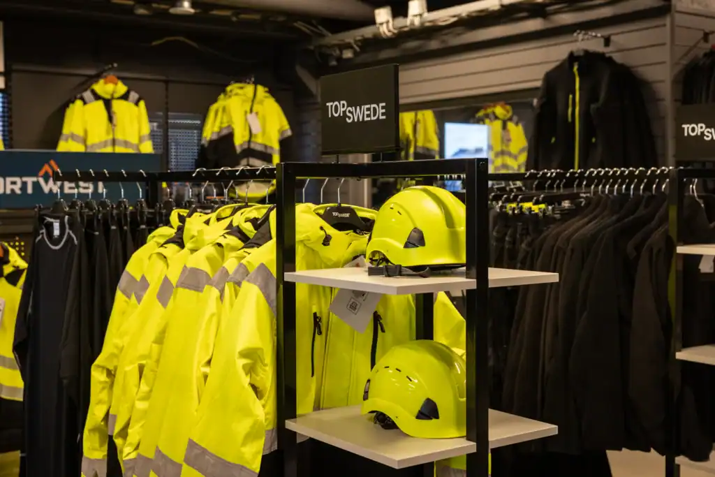 Arbetskläder och hjälmar på hylla i butik i strängnäs